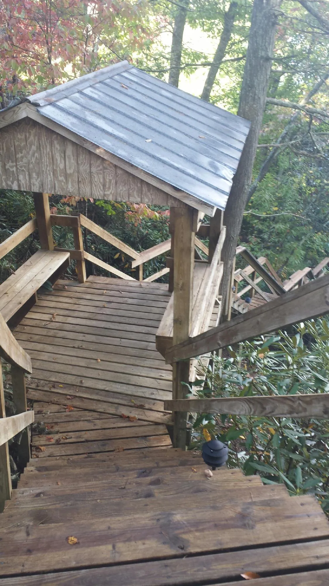 Metal roofed shelter over wooden steps on a wooded walkway — Skylight Repair & Installation work by our crew in Silverthorne